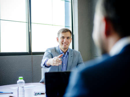Young man in suit, at desk in office. Close-up .の写真素材