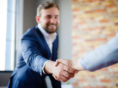 Men shaking hands. Confident businessman shaking hands with each other.の写真素材