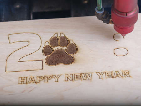 Automated machine for the burning of patterns on the tree began its work with the logo of the paw...