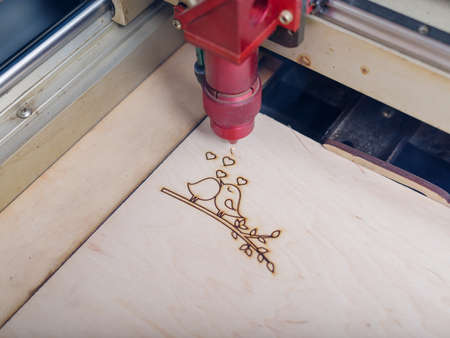 Automated machine for burning out patterns on the tree began its work on close-up patternsの写真素材