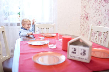 A beautiful festive table served with a red tablecloth. Glasses, plates, napkins for holidays table at home. Close-up of objects. Holiday concept.の写真素材