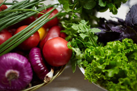 A top view on organic vegetables. Green onion, dill, parsley, tomatoes, celery, sorrel and many other vegetables in wooden plates. Close-up of vegetables. Food concept.の写真素材