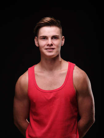 Portrait of a man on a black background in a red tank top.の写真素材