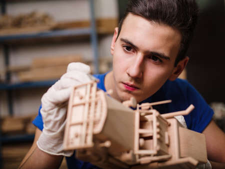 Wooden car close-up with hands of the masterの写真素材