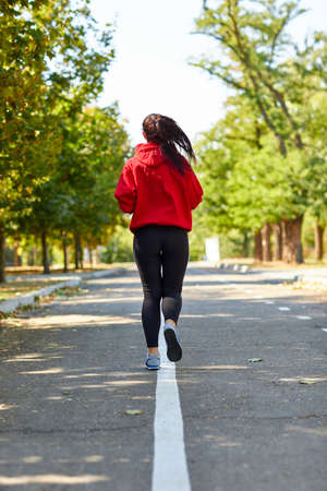 Sporty girl jogging listening to music on the streetの写真素材