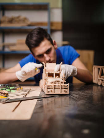 Wooden car close-up with hands of the masterの写真素材