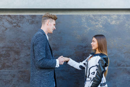 A beautiful woman smiles, shaking the mans hand.の写真素材