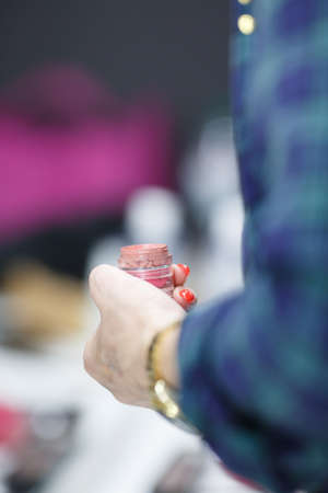 Make-up artist in the hand holds lipstick. Close-up.の写真素材
