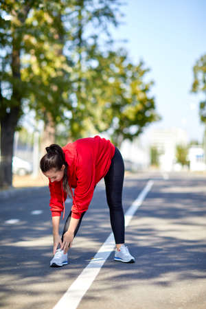 Girl on a warm-up in the street in the park