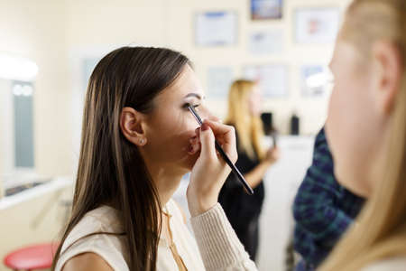 A make-up artist is applying makeup to a young girl.の写真素材