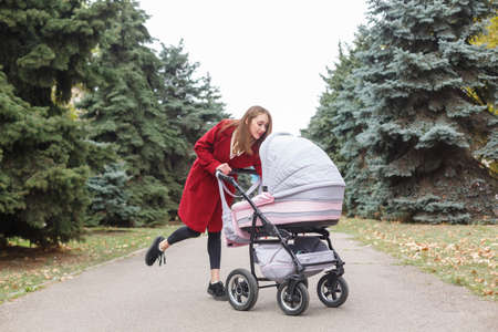Young beautiful mom walking with baby in the park.の写真素材