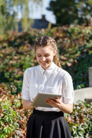 Young girl in the park with a tablet in hand.の写真素材