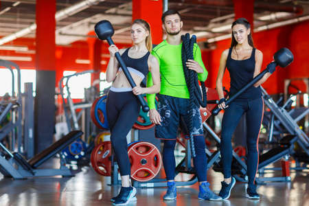Athletes in the gym are posing with a hammer and a rope.の写真素材