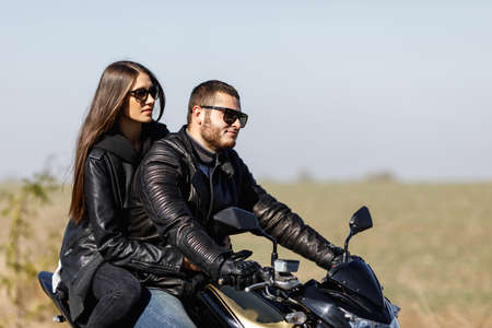 A close-up of a motorcycle stands on the road with its owner alone