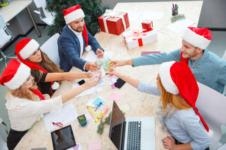 Office team drinking on Christmas on the office background. Xmas party. Christmas champagne concept.の写真素材