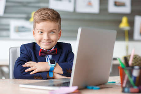 Small businessman sitting at workplace and working at computer