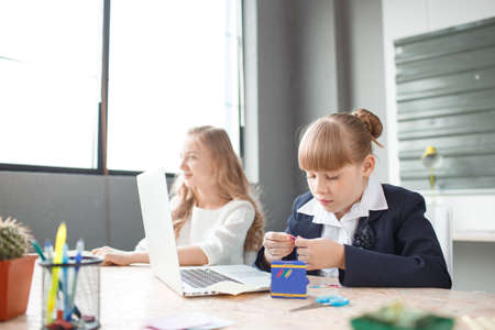A small businesswoman works at a computer and is helped by an employeeの写真素材