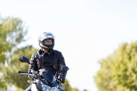 A close-up of a motorcycle stands on the road with its owner alone