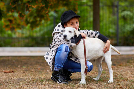 Beautiful young girl playing with dog outdoors. Pet concept.の写真素材