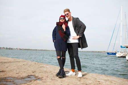 Cheerful young couple having fun and laughing together outdoors.の写真素材
