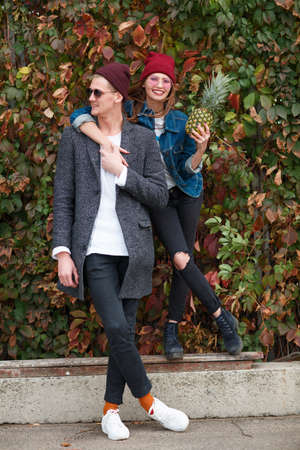 Cheerful young couple having fun and laughing together outdoors.の写真素材