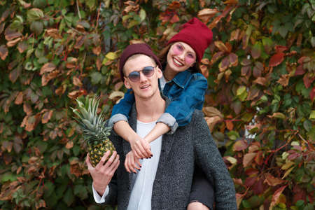 Cheerful young couple having fun and laughing together outdoors.の写真素材