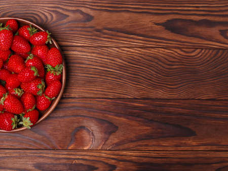 Fresh ripe fruits on a wooden table. Sweety red strawberries summer fruits on a dark background. Copy space. Close-up of strawberry. Food concept.の写真素材
