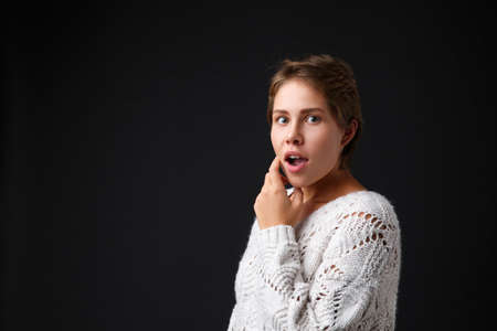 Dark-haired girl with short hair on a black background.の写真素材