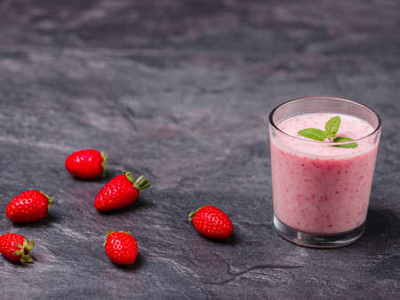 Tasty sweet strawberries and fruits yogurt in a glass on a gray marble background. Healthy organic drink. Copy space. Food concept.の写真素材