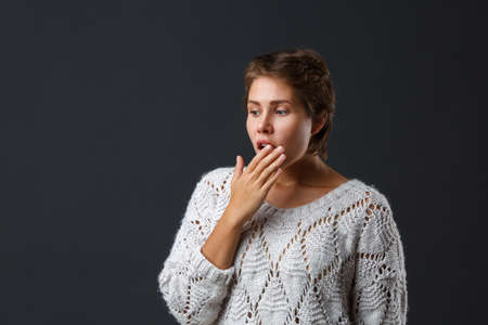 Dark-haired girl with short hair on a black background.の写真素材