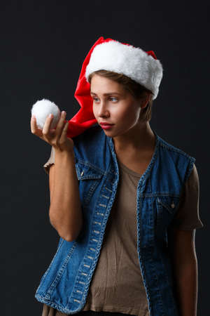 Young woman in santa hat on black background.の写真素材