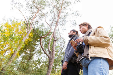 Young couple in the woods looking for a road with a phone.の写真素材