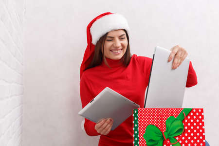 The girl unpacks a gift in a red bag