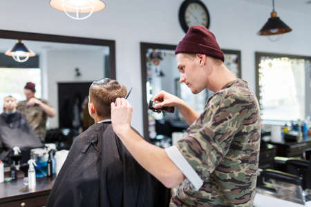 Hairdresser barbershop parihopher strechot small boy sitting on a chairの写真素材