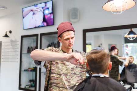 Hairdresser barbershop parihopher strechot small boy sitting on a chair