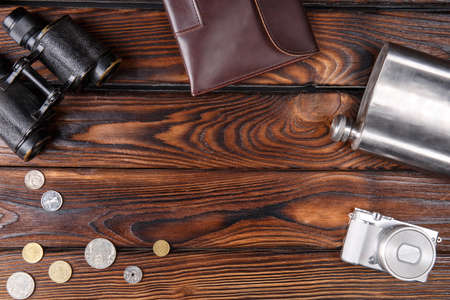 A set of travel accessories on a wooden background. Coins, glasses, binoculars, Passport. Close-up set for travel.の写真素材