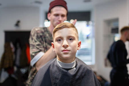 Hairdresser barbershop parihopher strechot small boy sitting on a chairの写真素材