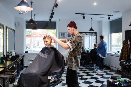 Hairdresser barbershop parihopher strechot small boy sitting on a chairの写真素材
