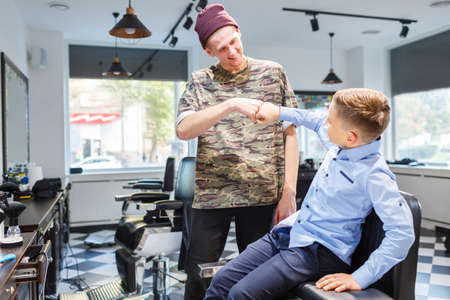 Hairdresser barbershop parihopher strechot small boy sitting on a chairの写真素材