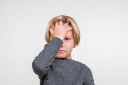 Pensive handsome little boy posing in the studio.の写真素材