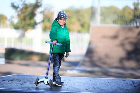 A boy plays in the autumn on the streetの写真素材