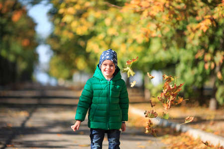 A boy plays in the autumn on the streetの写真素材