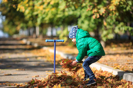 A boy plays in the autumn on the streetの写真素材