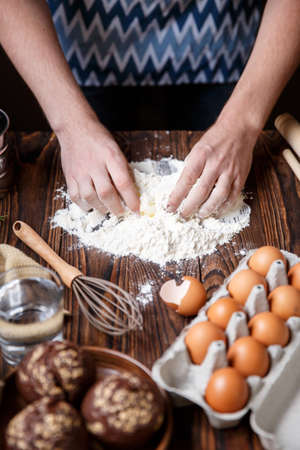 Men's hands are dirty in wheat flour near the tray with chicken eggs. Inside.の写真素材