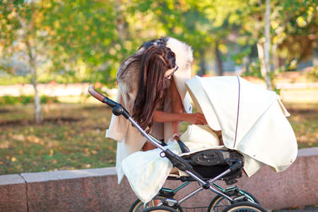 Mom corrects the baby in the stroller.の写真素材