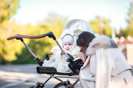 The dark-haired mother plays with the child in the street.