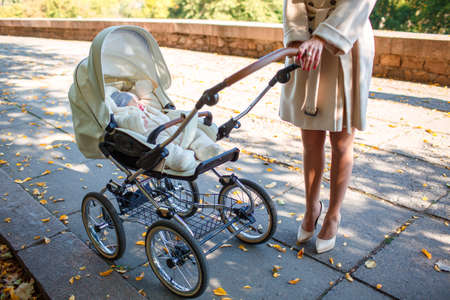 A thin girl on her heels is standing with a sidecar in the street during the day.の写真素材
