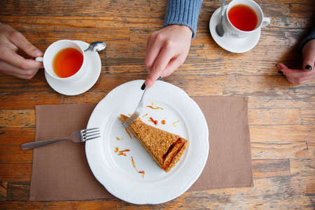 Delicious and sweet cake with cups of tea on wooden table.の写真素材