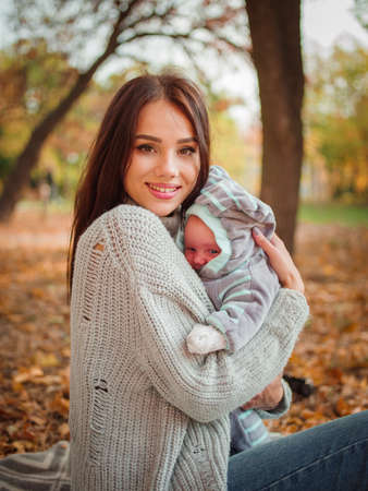 The girl is holding her son in the parkの写真素材