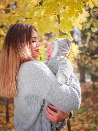 The girl is holding her son in the park